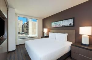 a bedroom with a large bed and a large window at Hyatt House Denver Downtown in Denver +46 photos