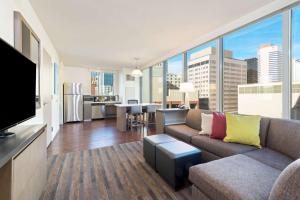a living room with a couch and a large window at Hyatt House Denver/Downtown in Denver