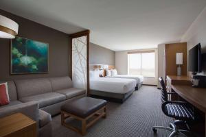 um quarto de hotel com uma cama e um sofá em Hyatt Place DFW em Irving