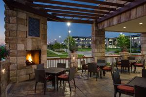 a patio with tables and chairs and a fireplace at Hyatt Place DFW in Irving