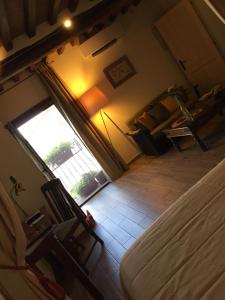 una camera con un letto e sedie e una finestra di Andante appartamenti a Castelnuovo di Val di Cecina