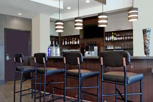 un bar con quattro sgabelli in una stanza di Hyatt Place Houston/Katy a Katy