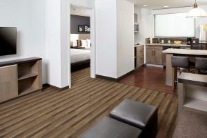 a hotel room with a bed and a kitchen at Hyatt House Denver Lakewood Belmar in Lakewood