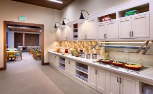 uma grande cozinha com armários brancos e uma sala de jantar em Hyatt Place Salt Lake City Farmington Station Park em Farmington