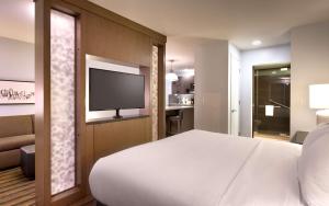 1 dormitorio con 1 cama blanca y TV de pantalla plana en Hyatt House Portland / Downtown en Portland