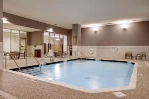 a large swimming pool in a room with tables and chairs at Hyatt Place St. Paul in Saint Paul