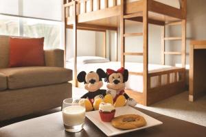 dois bichos de peluche sentados numa mesa ao lado de uma cama em Hyatt Place Orlando/Lake Buena Vista em Orlando