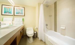 a bathroom with a toilet and a sink and a tub at Hyatt Place Orlando/Lake Buena Vista in Orlando