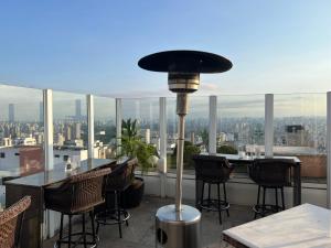 a balcony with a table and chairs and a view of the city at Hotel America International Jardins in Sao Paulo