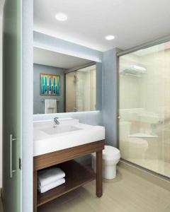 uma casa de banho com um lavatório, um chuveiro e um WC. em Hyatt Place Austin Airport em Austin