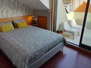 um quarto com uma cama e vista para uma varanda em Top floor apartment with Sunny Balconies no Porto
