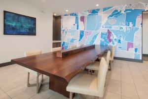 a dining room table with chairs and a large wall at Hyatt Place Cincinnati/Sharonville Convention Center in Sharonville
