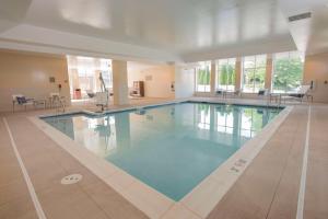 a large swimming pool with blue water in a building at Hyatt Place Cincinnati/Sharonville Convention Center in Sharonville