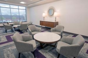 a waiting room with chairs and a table and a mirror at Hyatt Place Cincinnati/Sharonville Convention Center in Sharonville