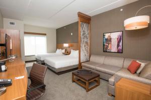 a hotel room with a couch and a bed at Hyatt Place Cincinnati/Sharonville Convention Center in Sharonville