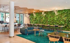 a living wall in a restaurant with a couch and tables at Hyatt Regency Amsterdam in Amsterdam