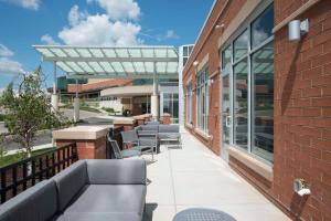 eine Terrasse mit Stühlen und Tischen auf einem Gebäude in der Unterkunft Hyatt Place Cincinnati/Sharonville Convention Center in Sharonville