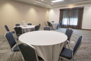 a conference room with two tables and chairs in a room at Hyatt Place Cincinnati/Sharonville Convention Center in Sharonville