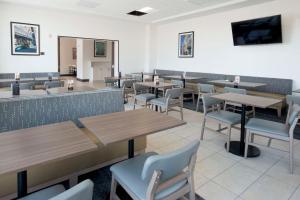 a restaurant with tables and chairs and a bar at Hyatt Place Cincinnati/Sharonville Convention Center in Sharonville