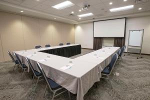a conference room with a table and chairs and a screen at Hyatt Place Cincinnati/Sharonville Convention Center in Sharonville