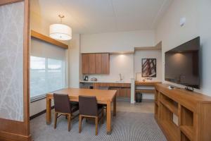 a kitchen with a dining room table and a television at Hyatt Place Cincinnati/Sharonville Convention Center in Sharonville
