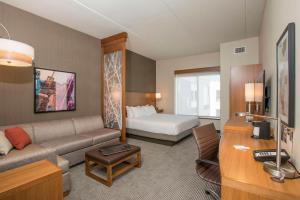 um quarto de hotel com um sofá e uma cama em Hyatt Place Cincinnati/Sharonville Convention Center em Sharonville