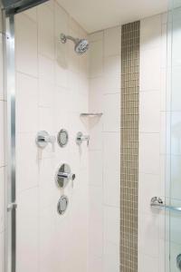 a bathroom with a shower with white tiles at Hyatt Place Cincinnati/Sharonville Convention Center in Sharonville