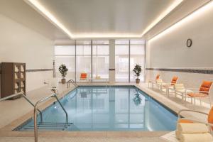 - une piscine avec des chaises orangées dans l'établissement Hyatt House Virginia Beach / Oceanfront, à Virginia Beach