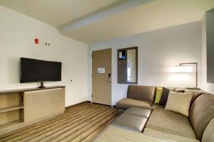 a living room with a couch and a flat screen tv at Hyatt House Chicago/Evanston in Evanston
