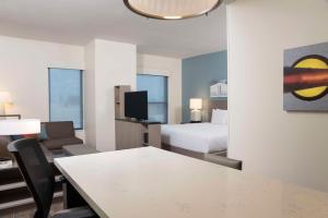 um quarto de hotel com uma cama e uma secretária com uma mesa em Hyatt House Austin/Downtown em Austin