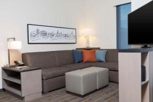 Hyatt House Austin/Downtown في أوستن: غرفة معيشة مع أريكة وتلفزيون بشاشة مسطحة