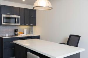 una cucina con armadi neri e piano di lavoro bianco di Hyatt House Austin/Downtown ad Austin