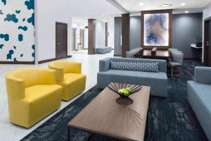 a lobby with couches and a table and yellow chairs at Hyatt Place Dallas/Allen in Allen