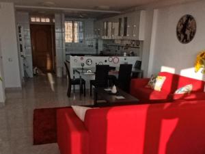 a living room with a red couch and a table at El Espejo del Mar in Almería