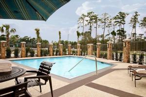 - une piscine avec une table et des chaises à côté d'une clôture dans l'établissement Hyatt Place Houston NW Vintage Park, à Houston