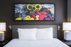 1 dormitorio con 1 cama y una pintura de flores en Hyatt House New York/Chelsea en Nueva York