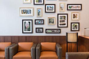 une salle d'attente avec un canapé et des photos sur le mur dans l'établissement Hyatt House Charleston - Historic District, à Charleston