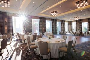 - une salle de banquet avec des tables, des chaises et des fenêtres dans l'établissement Hyatt House Charleston - Historic District, à Charleston
