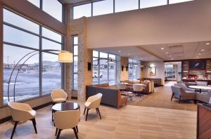 un hall de bureau avec des chaises, des tables et des fenêtres dans l'établissement Hyatt Place Salt Lake City/Lehi, à Lehi