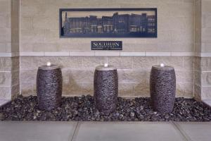 three stone pillar candles in a stone wall at Hyatt Place Chapel Hill in Chapel Hill