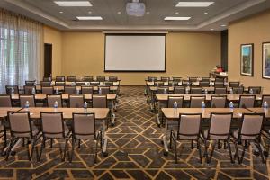 una sala de conferencias con mesas, sillas y una pizarra en Hyatt Place Chapel Hill en Chapel Hill