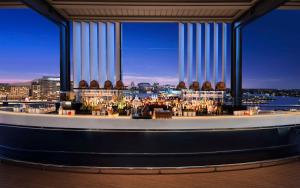 a bar on the top of a building with a view at Hyatt Regency Sydney in Sydney