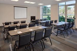 a conference room with tables and chairs and a whiteboard at Hyatt House Irvine/John Wayne Airport in Irvine
