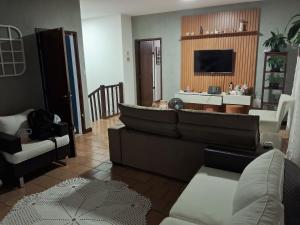 a living room with a couch and a tv at Aconchego in Araxá