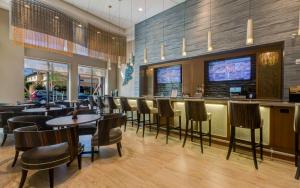 um restaurante com um bar com mesas e cadeiras em Hyatt Place Boca Raton em Boca Raton