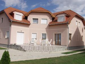 a house with chairs and a table in front of it at Lukács Ház in Bük