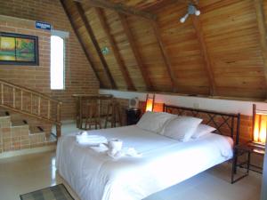 a bedroom with a white bed with a wooden ceiling at ASGARD Spa in San Agustín