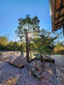 una terraza de madera con una palmera en un patio en Refúgio Tao Cerrado Chalé Brisa Da mata en Alto Paraíso de Goiás