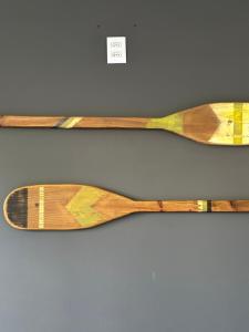 two wooden spoons are hanging on a wall at Apartamento na praia Garopaba San Pietro Sc loft 101 in Garopaba