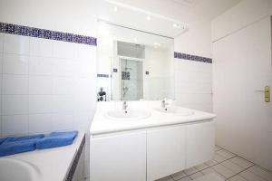 uma casa de banho branca com um lavatório e um espelho em Vue Paris (&tour Eiffel), Maison indépendante em Suresnes